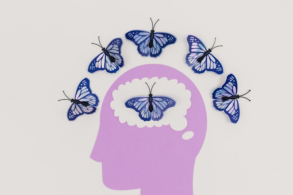 Illustration of a Head and Butterflies Around the Scalp and Inside the Brain
